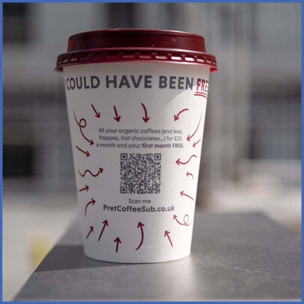 Ein Foto eines Kaffeebechers. Auf dem Kaffeebecher befindet sich ein QR-Code mit der Aufschrift “could have been free”.